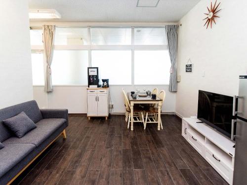 a living room with a couch and a table at El Sol Town Okinawa in Chatan