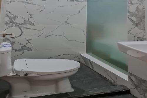 a bathroom with a white toilet and a sink at RedDoorz Plus @ Batutulis Bogor in Bogor