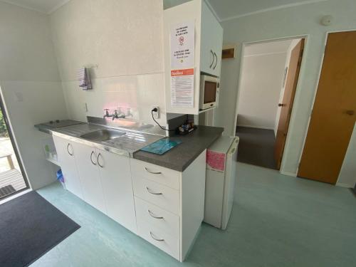 a small kitchen with a sink and a refrigerator at Opononi Lighthouse Motel in Opononi