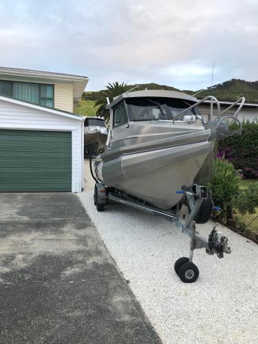 a boat parked in a driveway next to a garage at Opononi Lighthouse Motel in Opononi