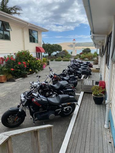 a row of motorcycles parked outside of a building at Opononi Lighthouse Motel in Opononi