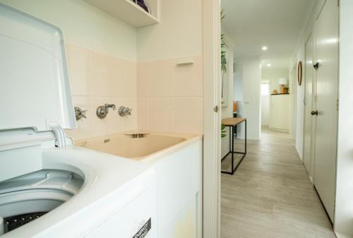 a bathroom with a washing machine and a sink at Top Of The Quays in Merimbula