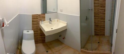 a white bathroom with a sink and a toilet at Vista Ashul Apartment 02 dormitorios in Lima