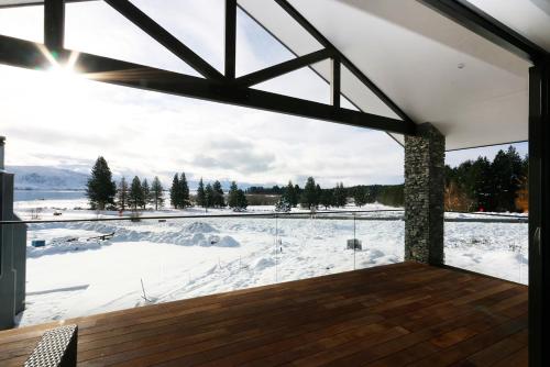 a room with a view of a snow covered field at Lake Views at Antler Lodge in Lake Tekapo