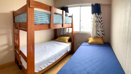 2 Etagenbetten in einem Zimmer mit Fenster in der Unterkunft Vista Ashul Apartment 02 dormitorios in Lima