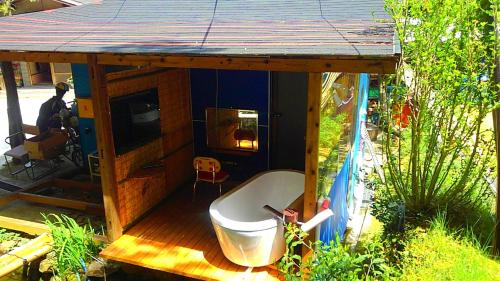a small house with a bath tub on a deck at 田舎の宿 吉田屋 in Ōgo