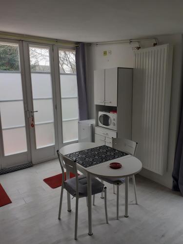 a kitchen with a table and chairs in a room at gîte " jardin peyrona" visite zoo beauval et châteaux de Loire in Beaulieu-lès-Loches