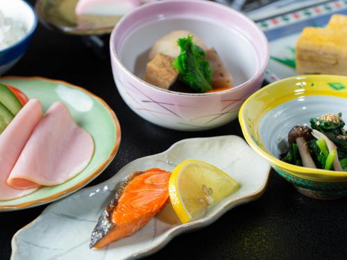 een tafel met borden en een kom eten bij Kaneyoshi Ryokan in Osaka
