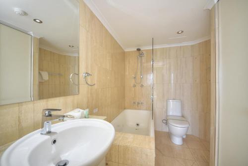 a bathroom with a sink and a toilet and a shower at 19th Avenue on the Beach in Gold Coast