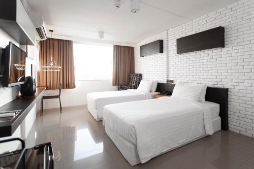 a hotel room with two beds and a kitchen at R1 Nimman Hotel Chiangmai in Chiang Mai