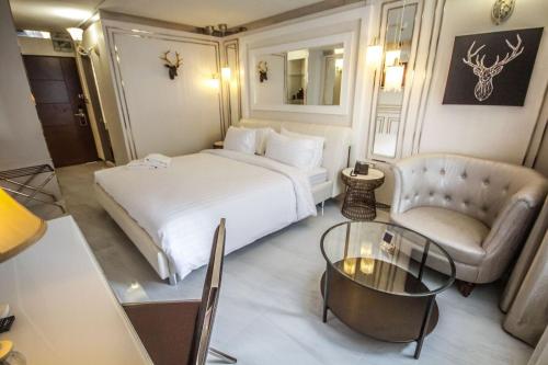 a hotel room with a bed and a chair and a table at R1 Nimman Hotel Chiangmai in Chiang Mai