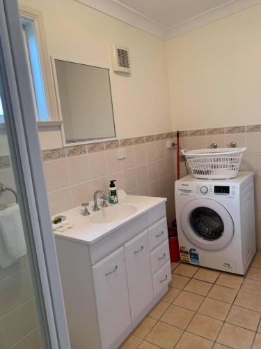 a bathroom with a sink and a washing machine at Units on Robertson in Mudgee