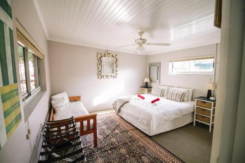 a bedroom with a bed and a chair at 90 On Wellington Cottage in Port Elizabeth