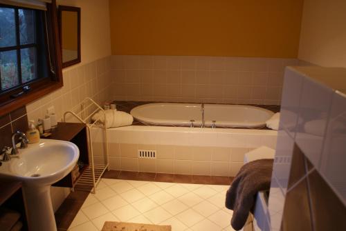 a bathroom with a tub and a sink at Yallambee B&B in Bundanoon