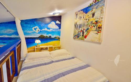 a bedroom with a painting on the wall at 花蓮 達芙妮花園民宿 in Jian