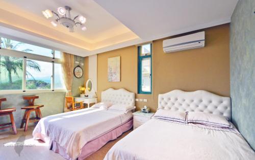 a bedroom with two beds and a window at 花蓮 達芙妮花園民宿 in Jian