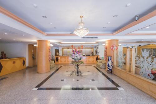 a lobby with a vase of flowers on the floor at Tzu Chi Hotel in Pingtung City