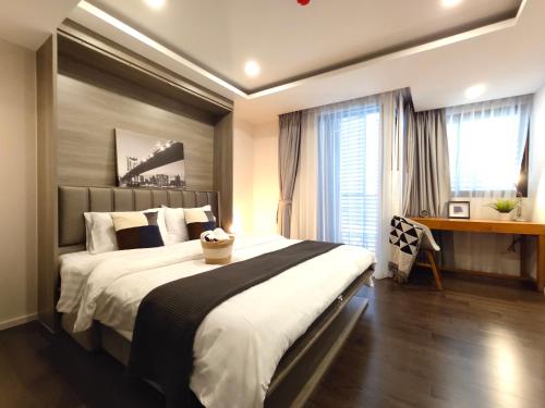 ein Schlafzimmer mit einem großen Bett und einem Schreibtisch in der Unterkunft Circle Rein Sukhumvit 12 #1BR#Pool&Gym#Near Terminal 21#Max2 in Bangkok