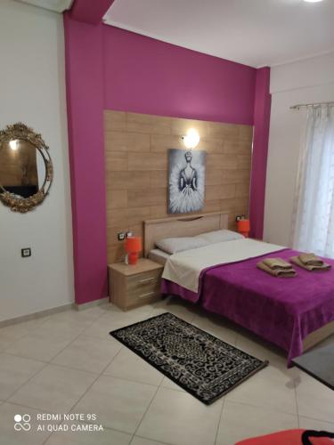 a bedroom with purple walls and a large bed at G M 4 ROOMS KENTRO in the heart of the city in Larisa