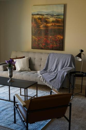 a living room with a couch and a painting on the wall at Sleepover 1BD 1BA Oklahoma City Apartments in Oklahoma City