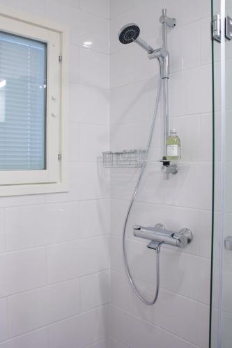 a shower with a shower head in a bathroom at Studio 7 - Air-conditioned, P-spot & Self Check-in in Jyväskylä