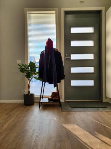 a room with a door and a coat on a stand next to a plant at Studio 7 - Air-conditioned, P-spot & Self Check-in in Jyväskylä