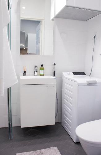 a white bathroom with a sink and a toilet at Studio 7 - Air-conditioned, P-spot & Self Check-in in Jyväskylä