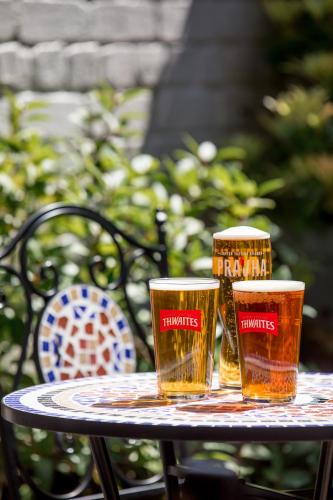 two glasses of beer sitting on a table at The Howard Arms in Brampton