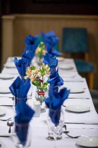 a long table with blue flowers in glass vases at The Howard Arms in Brampton