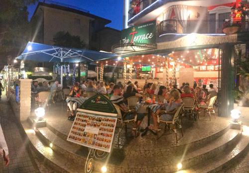 a group of people sitting at a restaurant at night at Milton Boutique Hotel - Adults Only in Lido di Jesolo