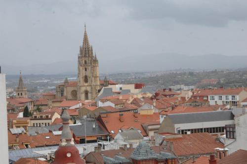 a view of a city with a church and roofs at Santacruz in Oviedo