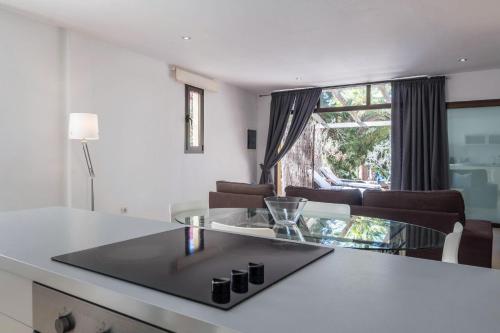 a kitchen with a glass table and a living room at Flamboyán in Adeje
