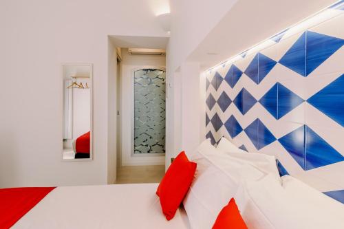 a bedroom with a white bed with red pillows at Monte Brusara Relais in Ravello