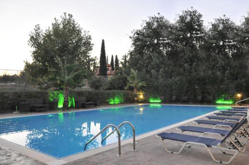 - une grande piscine bordée de chaises longues dans l'établissement Hotel Ena, à Loutra Ipatis
