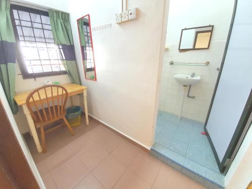 a bathroom with a sink and a toilet and a chair at Grand Star Hotel in Melaka