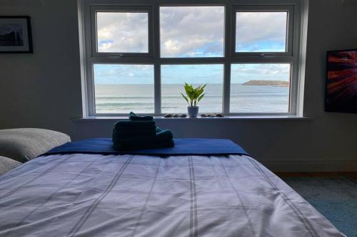 a bedroom with a bed with a view of the ocean at Island Dhu View - Seaside Penthouse in Portrush in Portrush