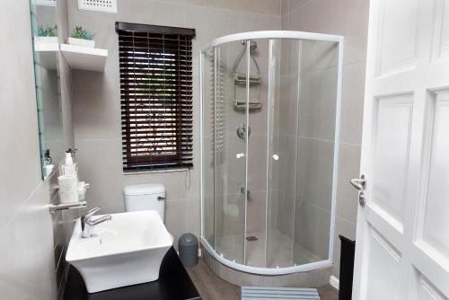 a bathroom with a shower and a sink at Whale-Inn in Durban