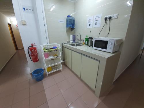 a kitchen with a sink and a microwave on a counter at Grand Star Hotel in Melaka