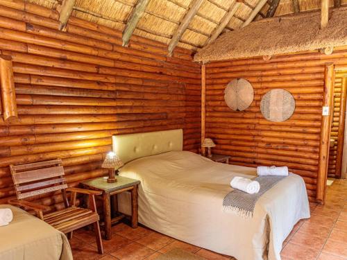 1 dormitorio con 2 camas en una cabaña de madera en Kwalata Game Lodge, en Klipdrift