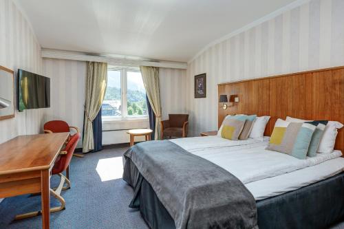 a hotel room with a large bed and a desk at Vøringfoss Hotel in Eidfjord