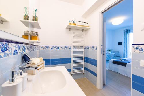 y baño azul y blanco con lavabo y ducha. en IL NOCCIOLO 12, Emma Villas, en Cecina