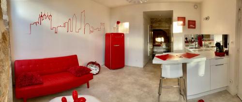 Ly'Ove في ليون: غرفة معيشة بها أريكة حمراء وثلاجة حمراء