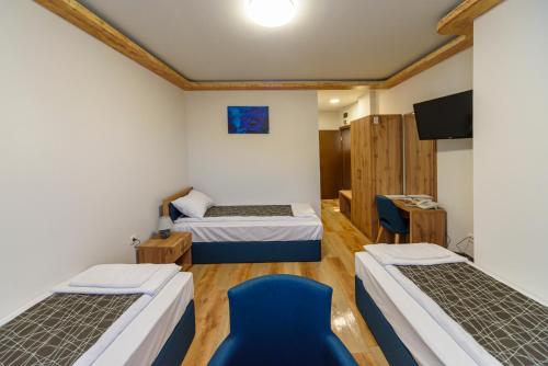 Bela Palanka的住宿－Garni Hotel Mala Moskva，一间设有两张床和一张蓝色椅子的房间