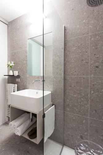 a bathroom with a sink and a glass shower at Hotel Tremoggia in Chiesa in Valmalenco