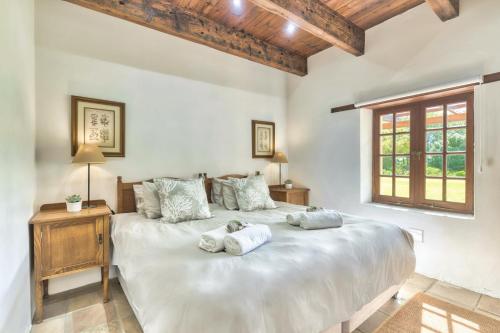 a bedroom with a large white bed with two pillows at Strandveld Vineyards Cottages in Elim