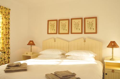 a bedroom with a white bed with towels on it at De Hoop Collection - Village Cottages in De Hoop Nature Reserve