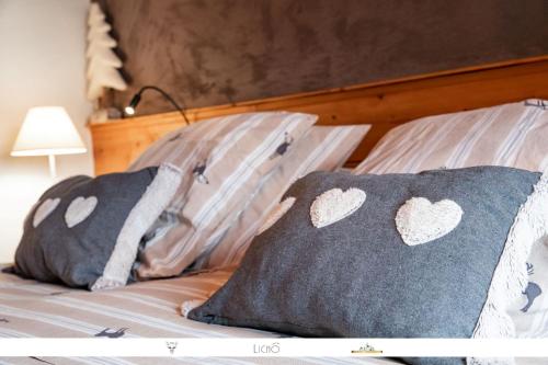 a bed with two pillows with hearts on them at Chez Mamie Anna (B&B et Chalet) in Bessans