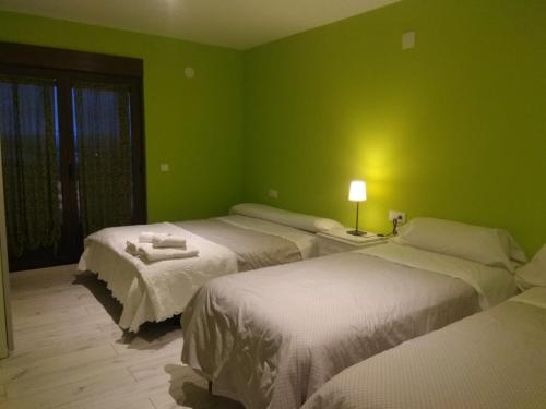 1 dormitorio con 2 camas y pared verde en Apartamento La Agripina, en Aldeadávila de la Ribera
