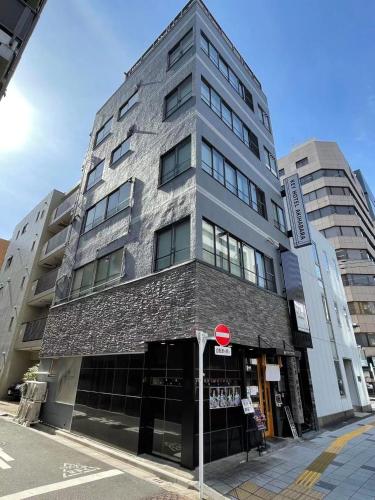 a tall brick building on a street with a stop sign at KEYHOTEL-5minutes for walk to Akihabara Electric Town in Tokyo