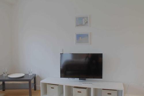 a flat screen tv sitting on top of a white table at Strandlaeufer NS6 Wremen in Wremen
